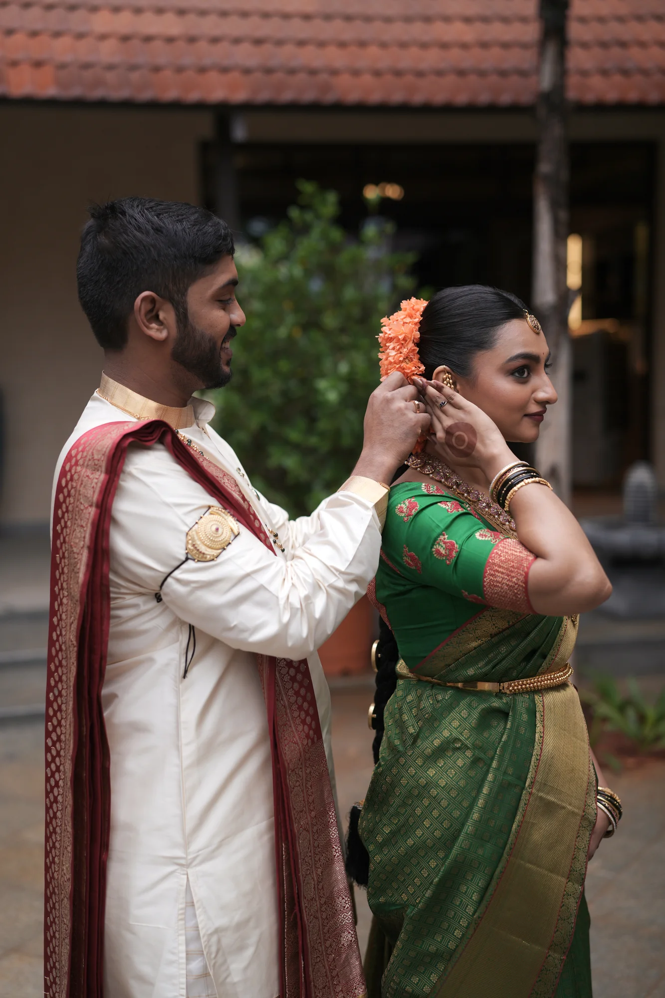 A groom helping his bride prepare for their wedding celebration
